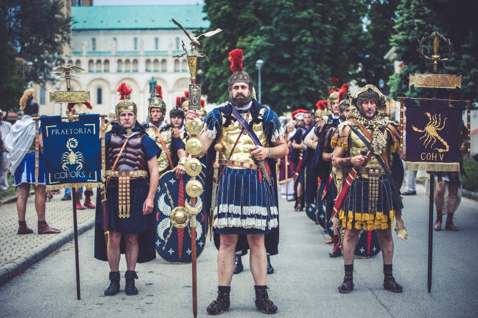 Rievocatori in abiti e armature romane con stendardi davanti alla cattedrale di Pécs