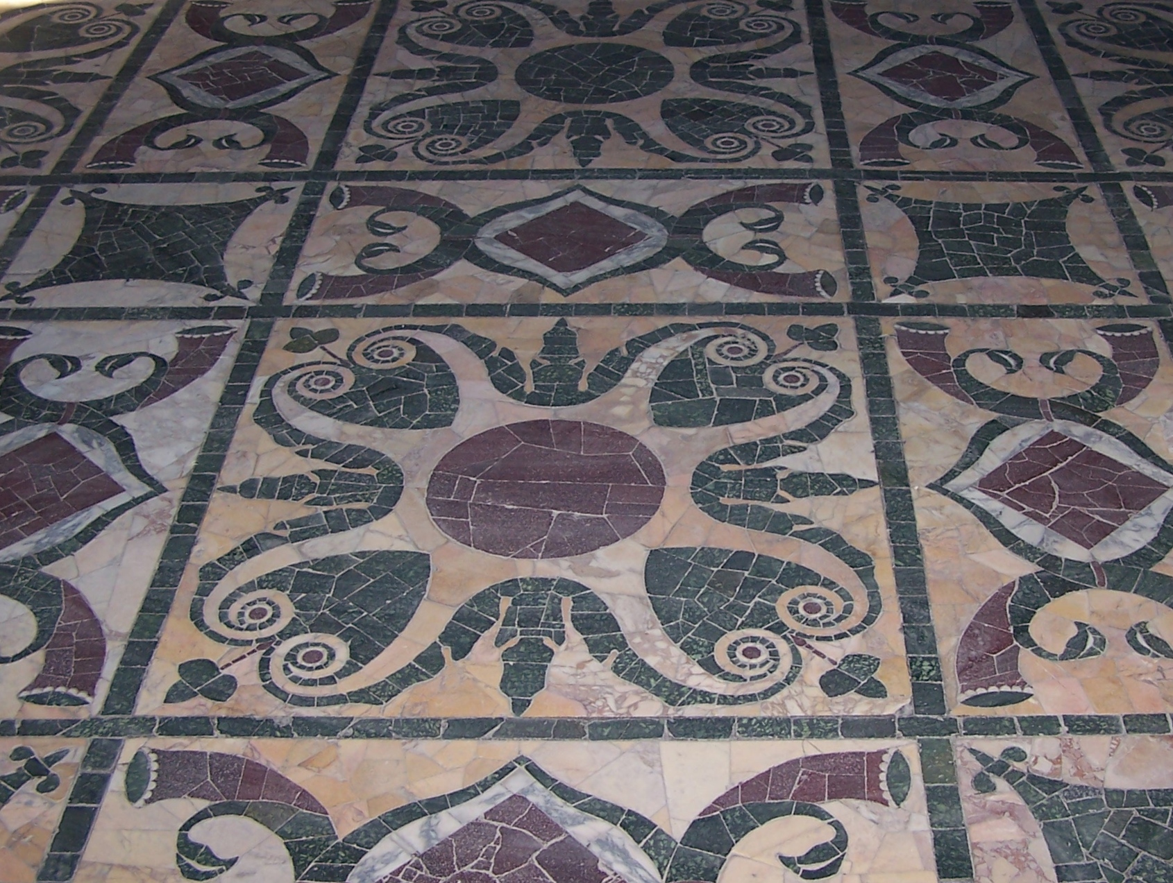 Interno della Curia Iulia: gradoni laterali per i senatori e pavimento in opus sectile. L’aspetto conservato appartiene alla ricostruzione tardoantica, restaurata in età moderna.